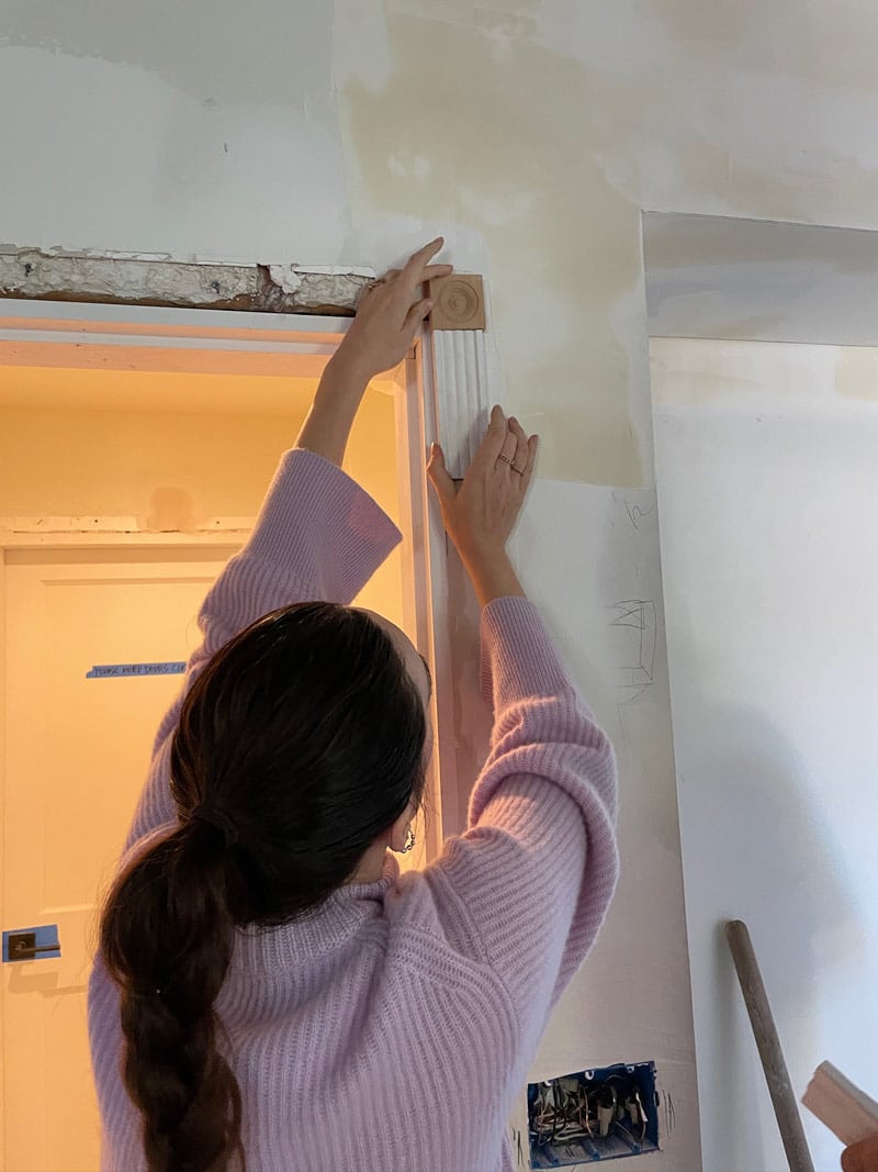 Allison holding moulding on doorway